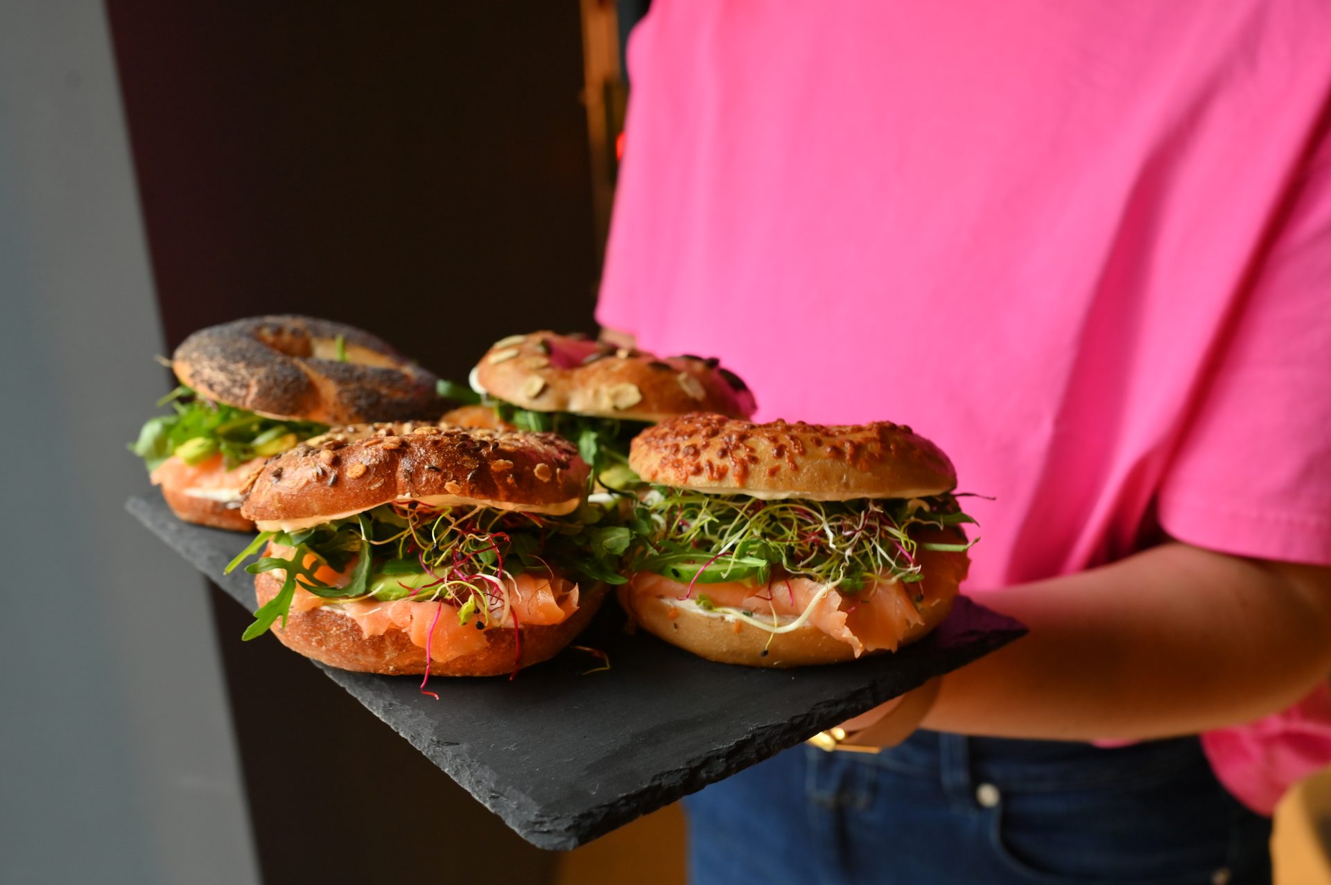 Assorted bagel sandwiches on slate board